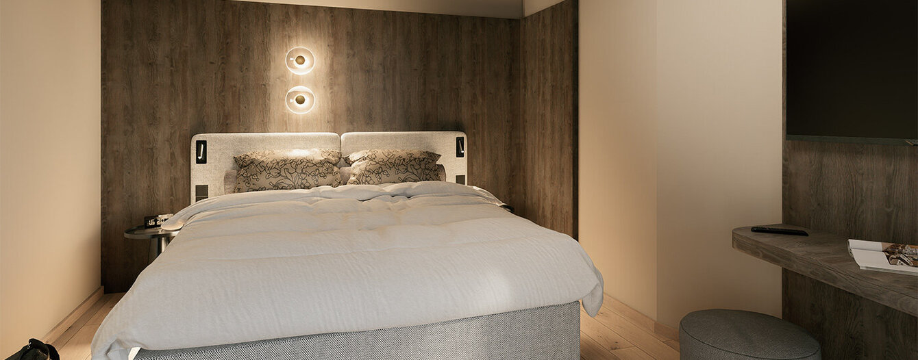 Ein modernes Schlafzimmer mit einem großen Bett, einem Kopfteil aus Holz, Einbauschränken, einem an der Wand montierten Fernseher und einem kleinen runden Hocker neben einem schwebenden Schreibtisch. Die Beleuchtung schafft eine warme, gemütliche Atmosphäre.