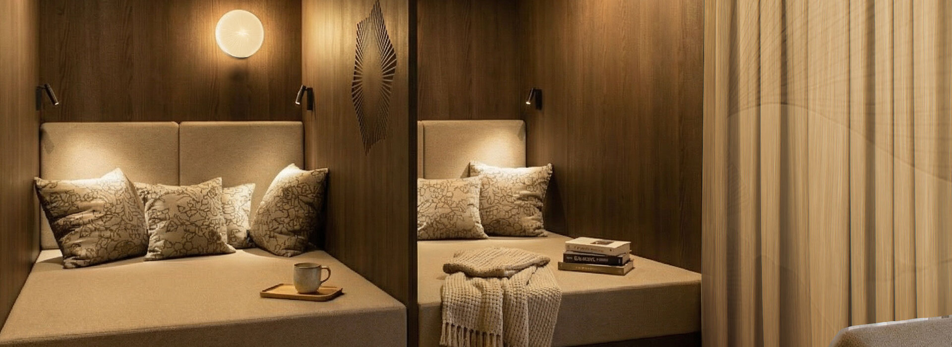 Zwei gemütliche, holzgetäfelte Sitzecken mit gepolsterten Bänken, gemusterten Kissen und gedämpfter Beleuchtung. In der einen stehen eine Tasse und ein Teller auf einem Tablett, in der anderen liegen Bücher und eine gefaltete Decke. Helle beige Vorhänge und eine kleine Pflanze sind ebenfalls zu sehen.