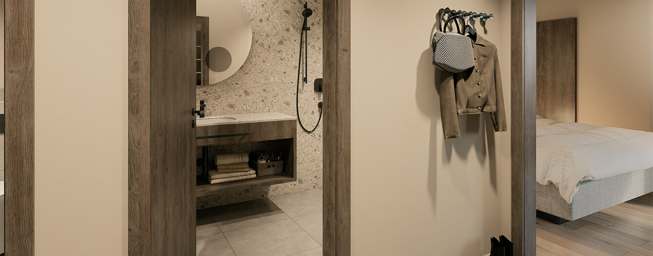 Ein moderner Flur mit beigen Wänden und hölzernen Türrahmen, der ein Badezimmer mit einem runden Spiegel und ein Schlafzimmer mit einem Bett zeigt. Ein Paar Schuhe sind an der Wand und auf dem Boden zu sehen.